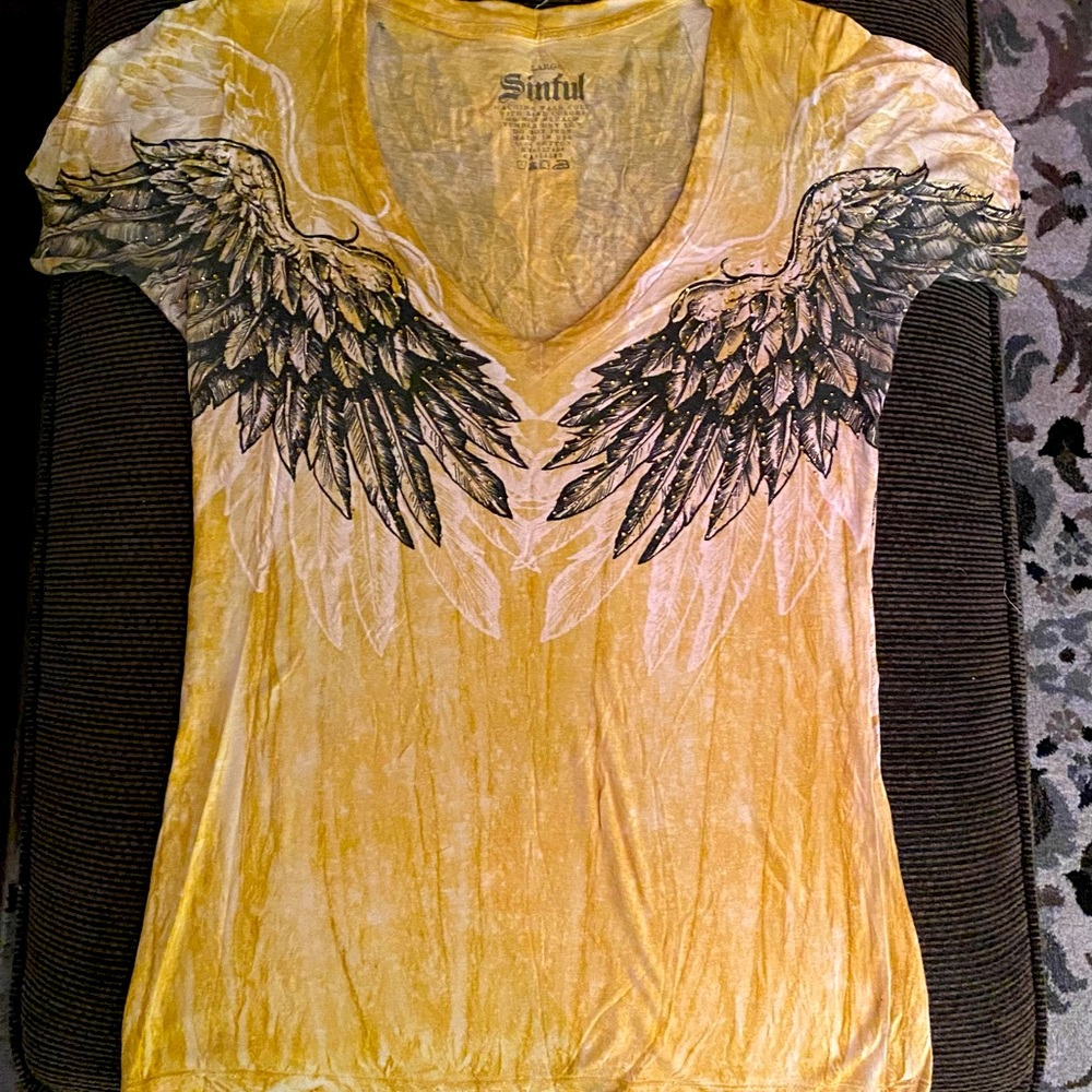 Mustard color. Sinful shirt! Beautiful wings on back of shirt.